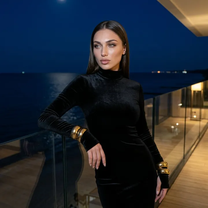 Lily in a black velvet dress on a luxury seaside terrace at night