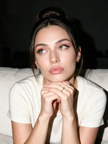 Close-up portrait of Lily resting her clasped hands beneath her chin
